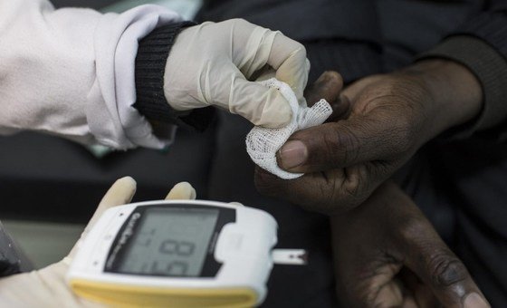 Un agent de santé effectuant un test de dépistage du diabète en Afrique